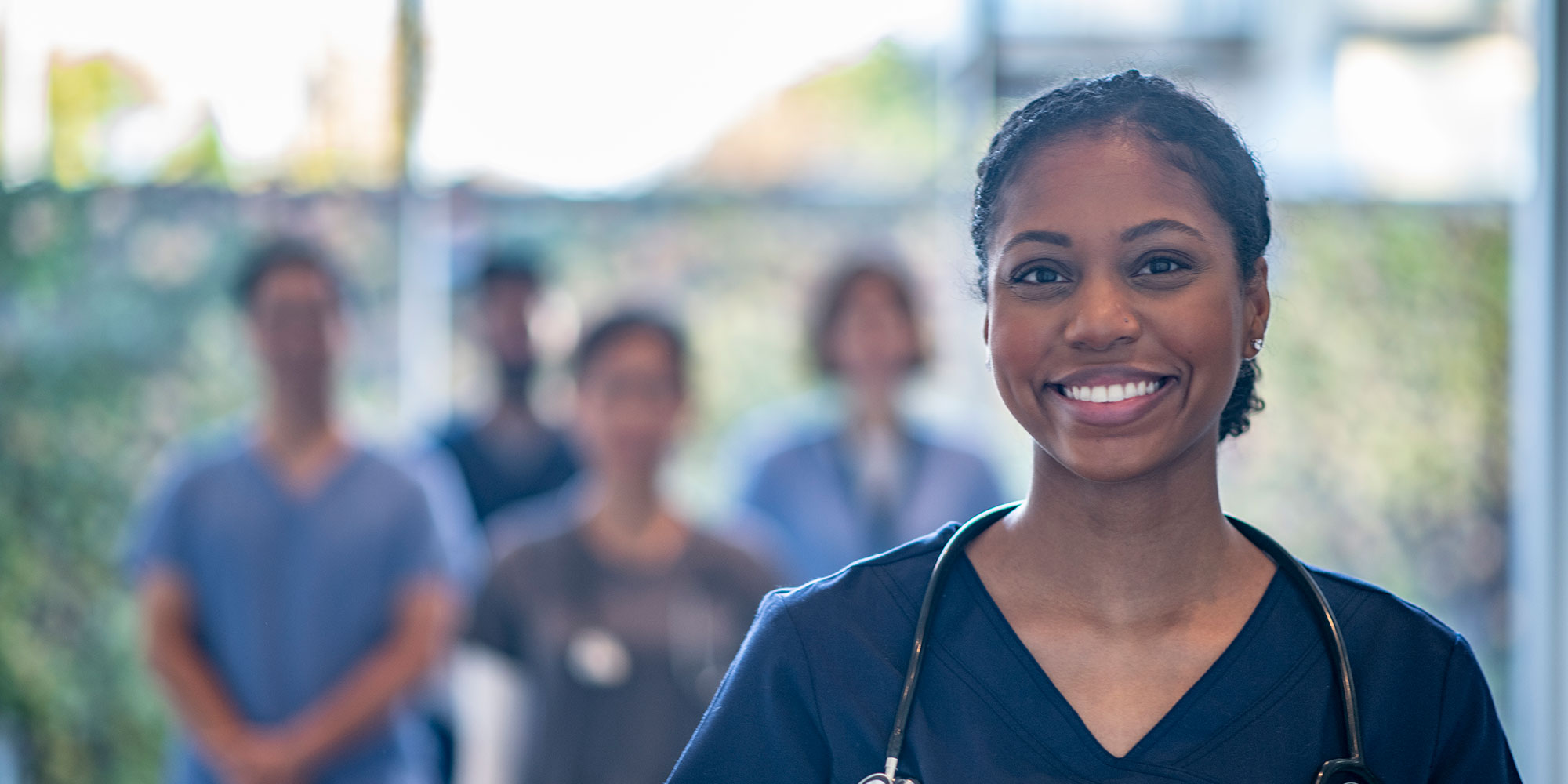 Medical Education residents smile in hospital hallway