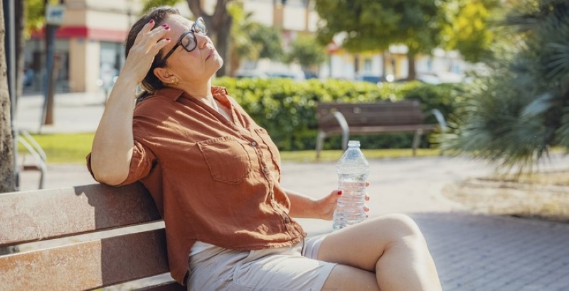 woman on bench during hot summer day