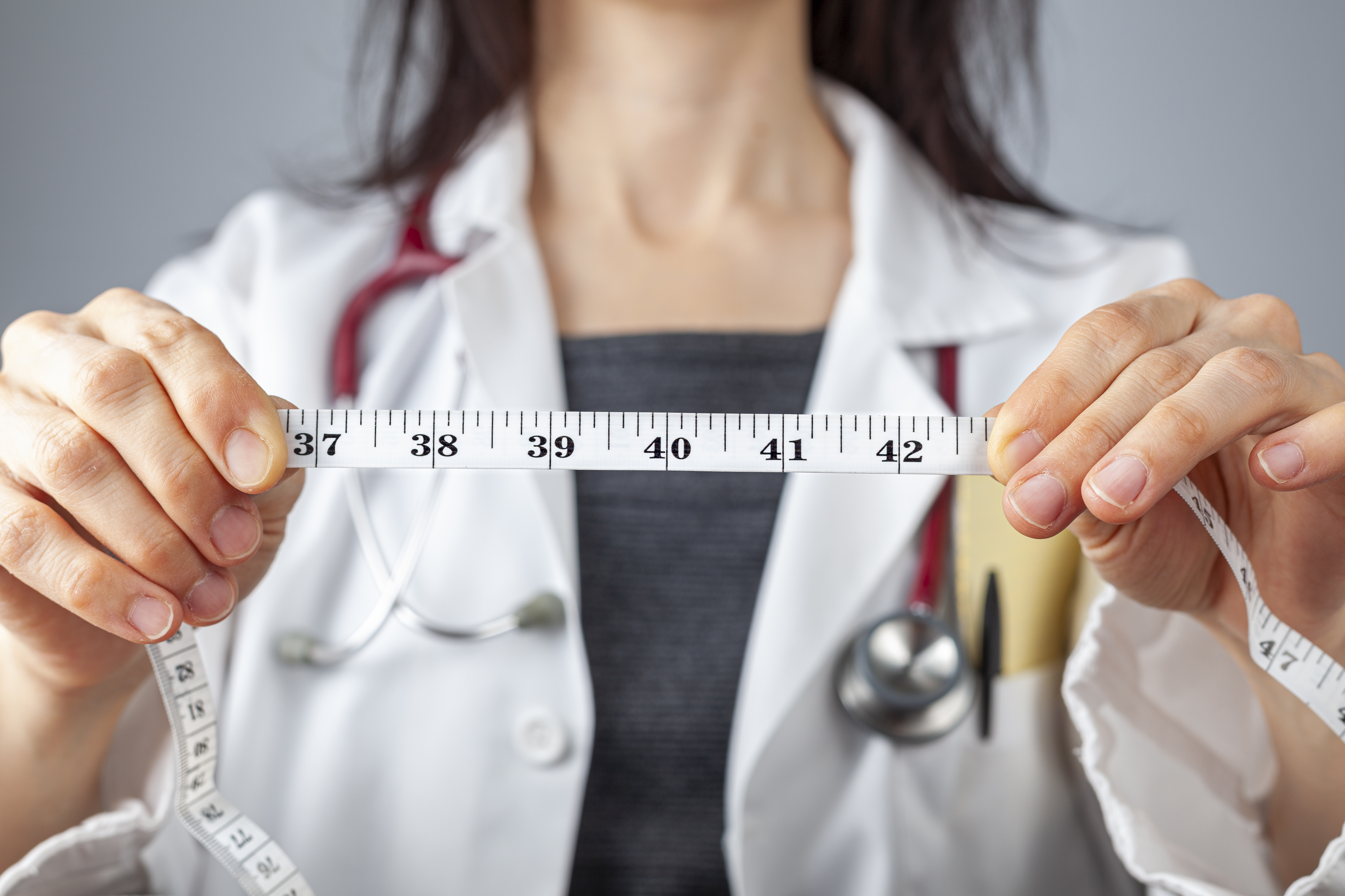 physician holding tape measure